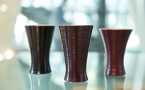 左から、オリジナル漆塗陶器の、轆轤目（ろくろめ）黒色漆杯、轆轤目溜塗杯、朱漆杯（各10500円）。
