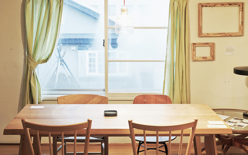 旭川は、家具のまちとしても有名で、多くのメーカーや職人が家具づくりに携わっている。そんな旭川の職人が手がけるLessオリジナルのダイニングテーブル。美しいガラスのランプは、ランドスケーププロダクツのもの。長野県にある「Studio Prepa」が製作を担当している。